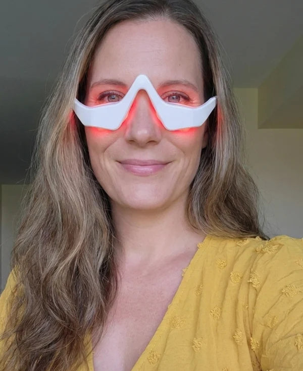 Woman wearing RevitalEyes™ red light therapy eye mask to reduce dark circles and puffiness